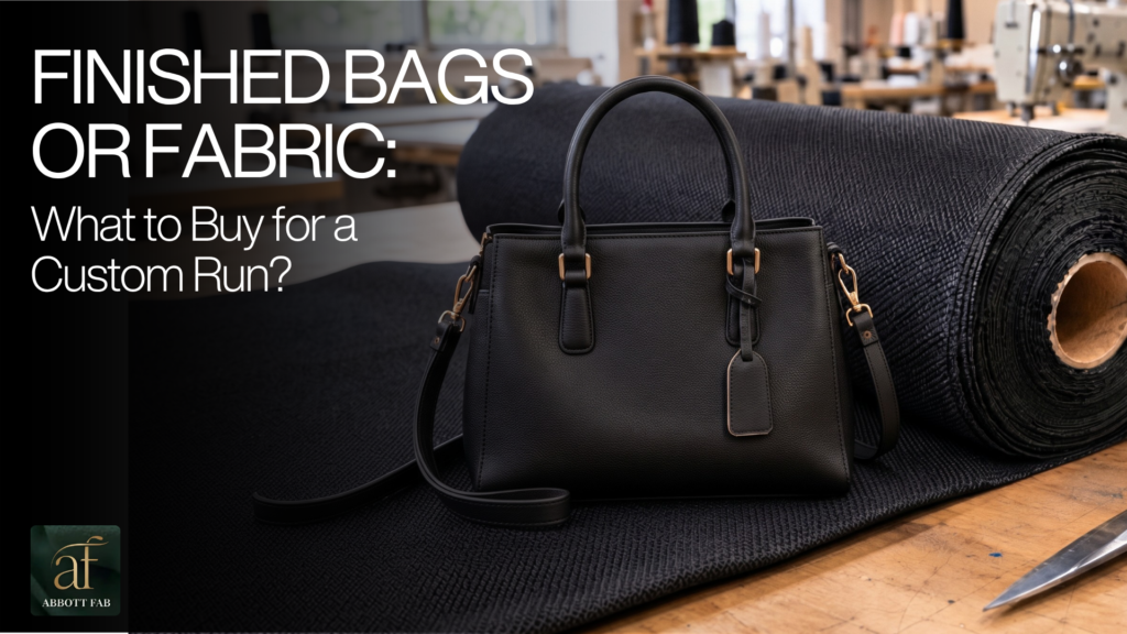 Abbott Fab header graphic featuring the Abbott Fab logo, headline FINISHED BAGS OR FABRIC: What to Buy for a Custom Run?, and a photograph of a black leatherette handbag resting on top of a large rolled bolt of textured synthetic fabric in a manufacturing workshop.